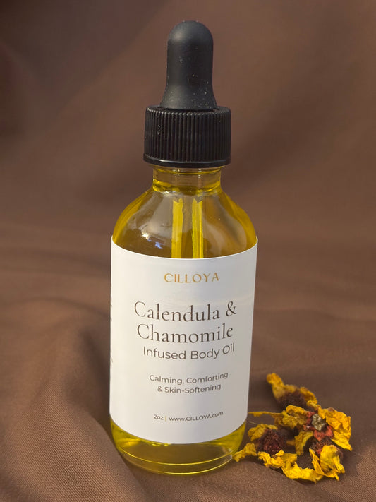 Bottle of Cilloya Calendula & Chamomile infused body oil with a dropper on a brown background