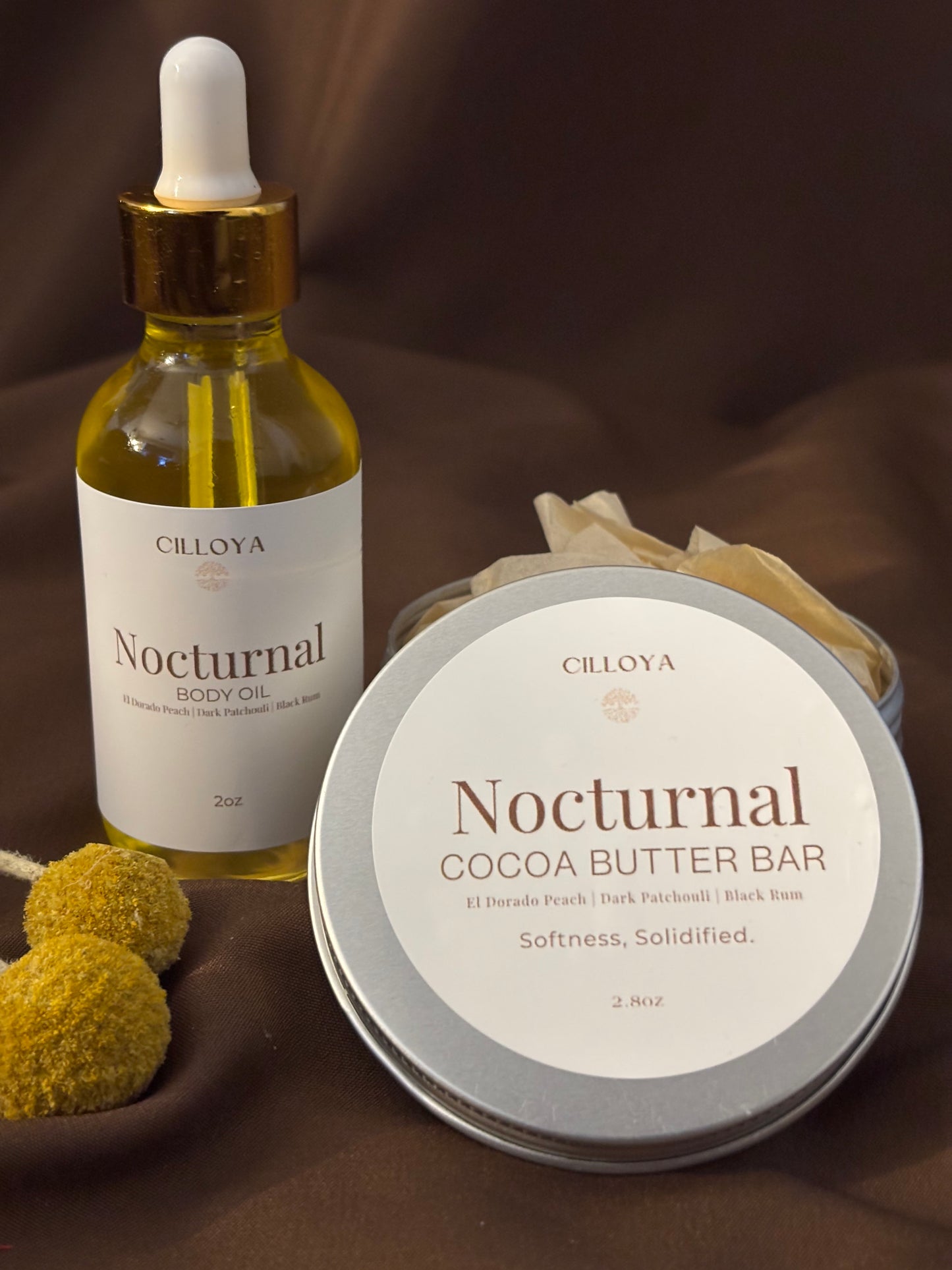 Cilloya Silk Experience gift set featuring a 2oz Nocturnal Body Oil and a 2.8oz Nocturnal Cocoa Butter Bar tin on a dark brown backdrop