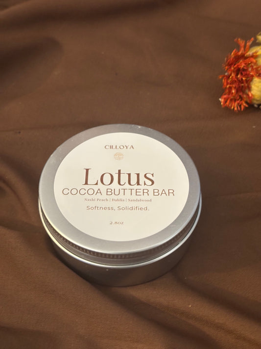 Lotus Cocoa Butter Bar round, silver tin container on a dark brown background