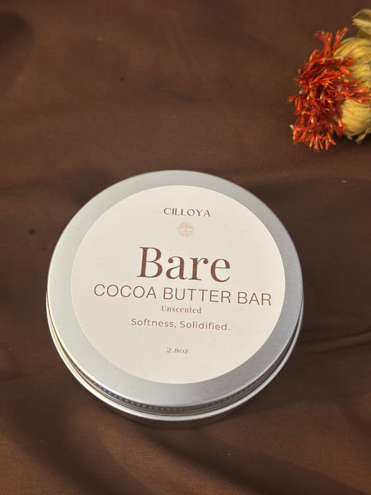 Cilloya Bare (Unscented) Cocoa Butter bar round tin container on a dark brown backdrop